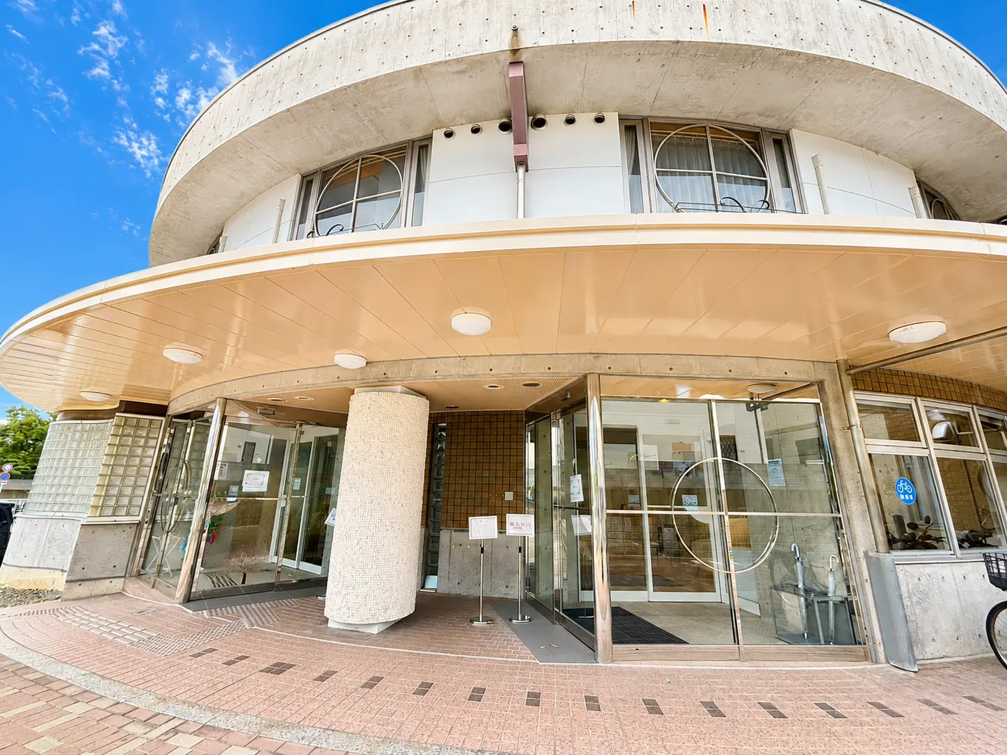 青空の下に建つ産後ケア施設さくらセレニティのエントランス